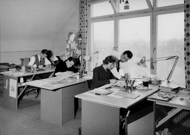 Knut Borg, Ateljéinteriör, 4 personer (en av landets modernaste ateljéer). Sven Hallberg (ateljéchef), fröken Ingela Reimers (layout-kvinna), Tore Nordlinder (layout-man) och Lars Söderberg (specialist på originalteckningar). Sedell Reklam AB, Storgatan 47, Örebro.