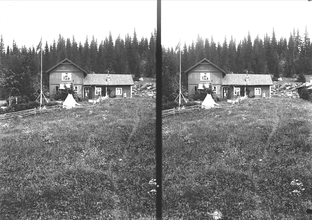 Axel Quinsgaard Wiborg, Hus på Holoa seter, Hadeland, Jevnaker, Oppland, 1903. Flagg og telt. Gudrun og Karen Q. Wiborg utenfor.