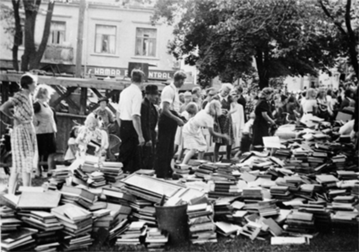 Anno Domkirkeodden, BIBLIOTEKETS BØKER STABLET, GRESSPLEN, TRIANGELEN, MYE FOLK. Folk dannet kjeder og fikk reddet alle biblioteksbøkene da folkebiblioteket i Torggata 65 brant. Etter brannen holdt biblioteket en periode til på Hamar Folkeskole og Pikeskolen før det i 1952 flyttet inn i nye lokaler i Handelens hus i S…