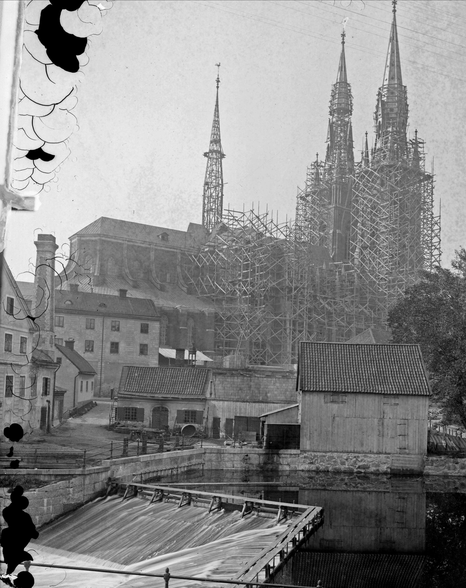 Okänd,, Uppsala domkyrka, Uppsala med byggnadsställningar. I förgrunden Akademikvarnens gård och Fyrisån med Kvarnfallet