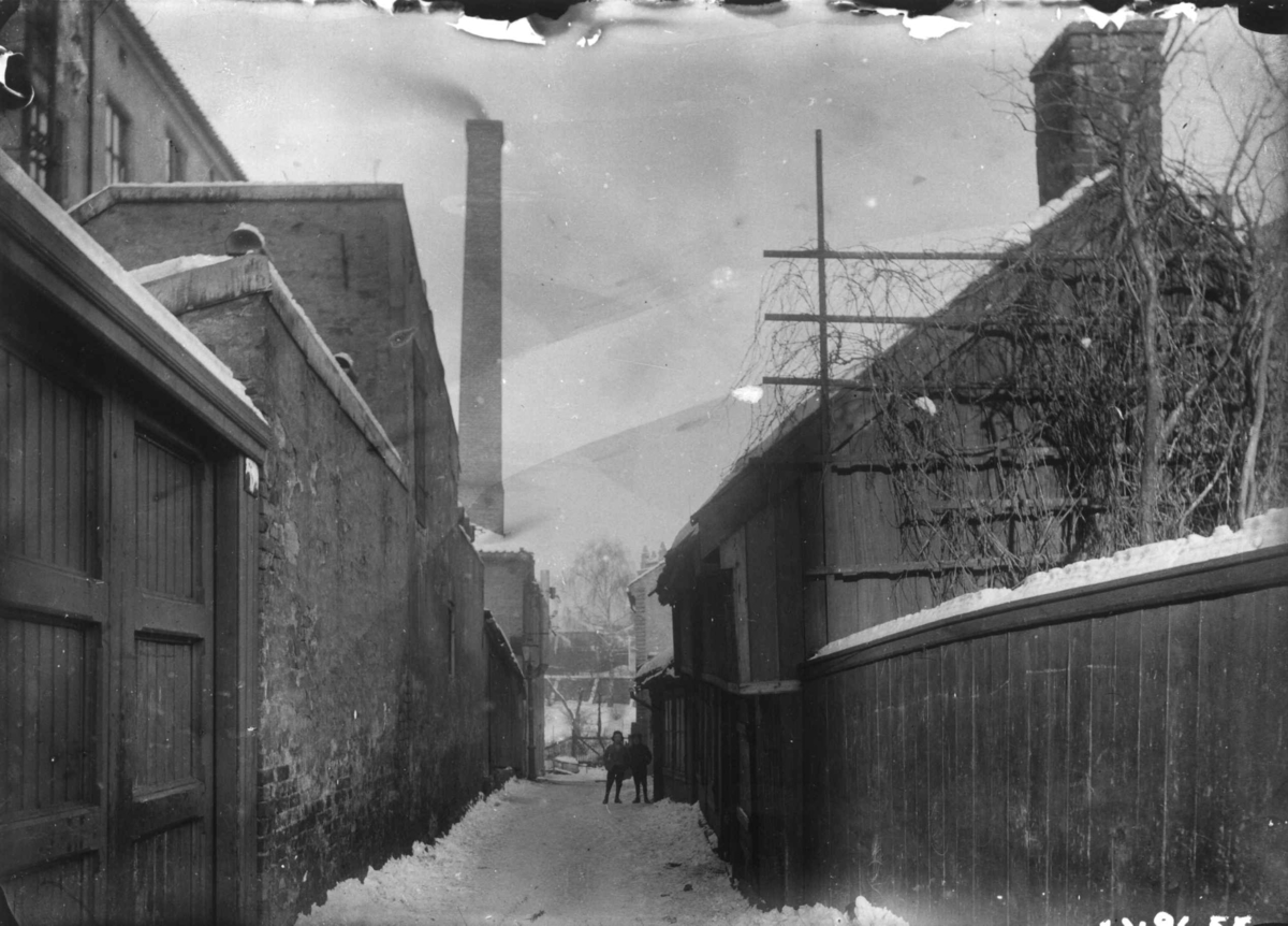 Nanna Broch, Smalgangen, Oslo. Tidligere gatestrimmel mellom Grønland og Breigata. Gateløp med sotpipe i bakgrunnen. Fra boliginspektør Nanna Brochs boligundersøkelser i Oslo 1920-årene.