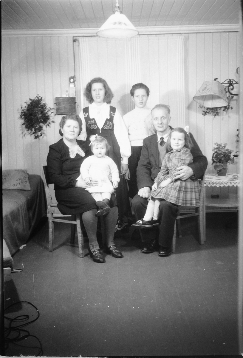 Håkon Prestkværn, Interiør, stue. Ukjent familiegruppe med kvinne i bunad. Fotokonvolutt mrk. "Thore Bårdseth julen 48"