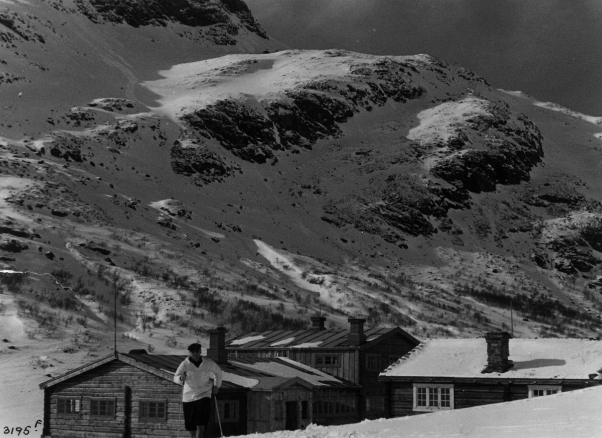 Anders Beer Wilse, Skiløper ved Spiterstulen i Visdalen i Jotunheimen med snødekte fjell.