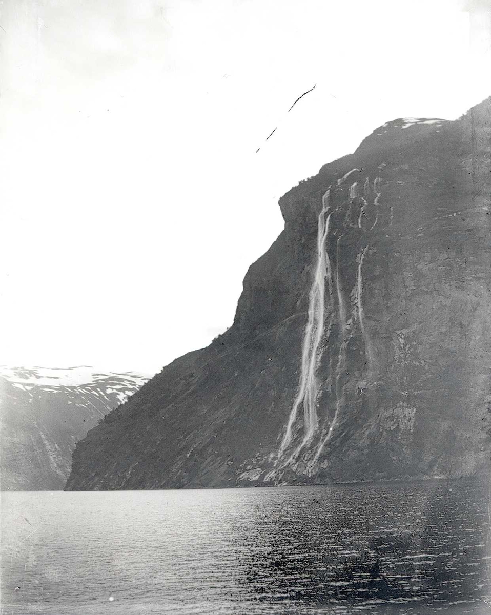 Tom Kent, Bilde tatt fra sjøen mot fjell med foss. Syv Søstre, Stranda, Geirangerfjord.