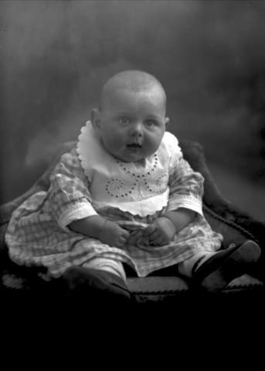 Gustav Borgen, Portrett, lite barn sittende. Rutete kjole. Skolebestyrer Thorolf Hansens sønn.