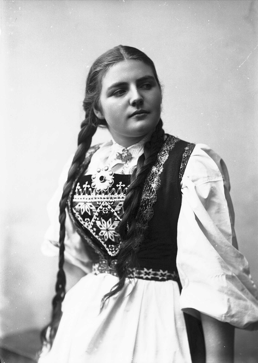 Solveig Lund, Studioportrett av kvinne i drakt med fletter i håret.