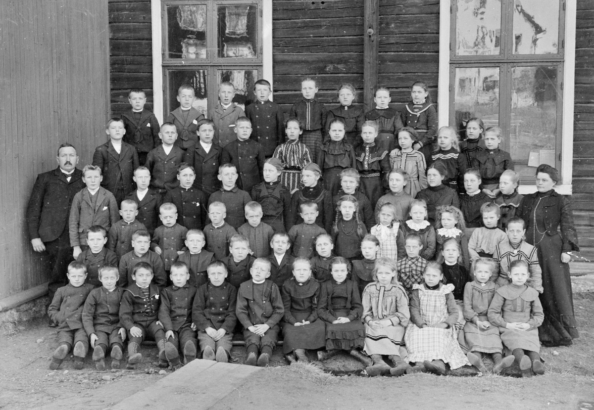 Anno Domkirkeodden, GR: 64 SKOLEELEVER. Skoleklasse foran kontorbygningen/skolebygningen ved Aadals Brug. Lærere på bildet er Johannes Raanaas, Aadalsbruk skole (1900-1910) og Mathilde Hauge, som selv hadde vært elev ved skolen. Lærerinne ved Aadalsbruk skole (1892-1918). Aadals Brug skole, elever og lærere. Skolen va…