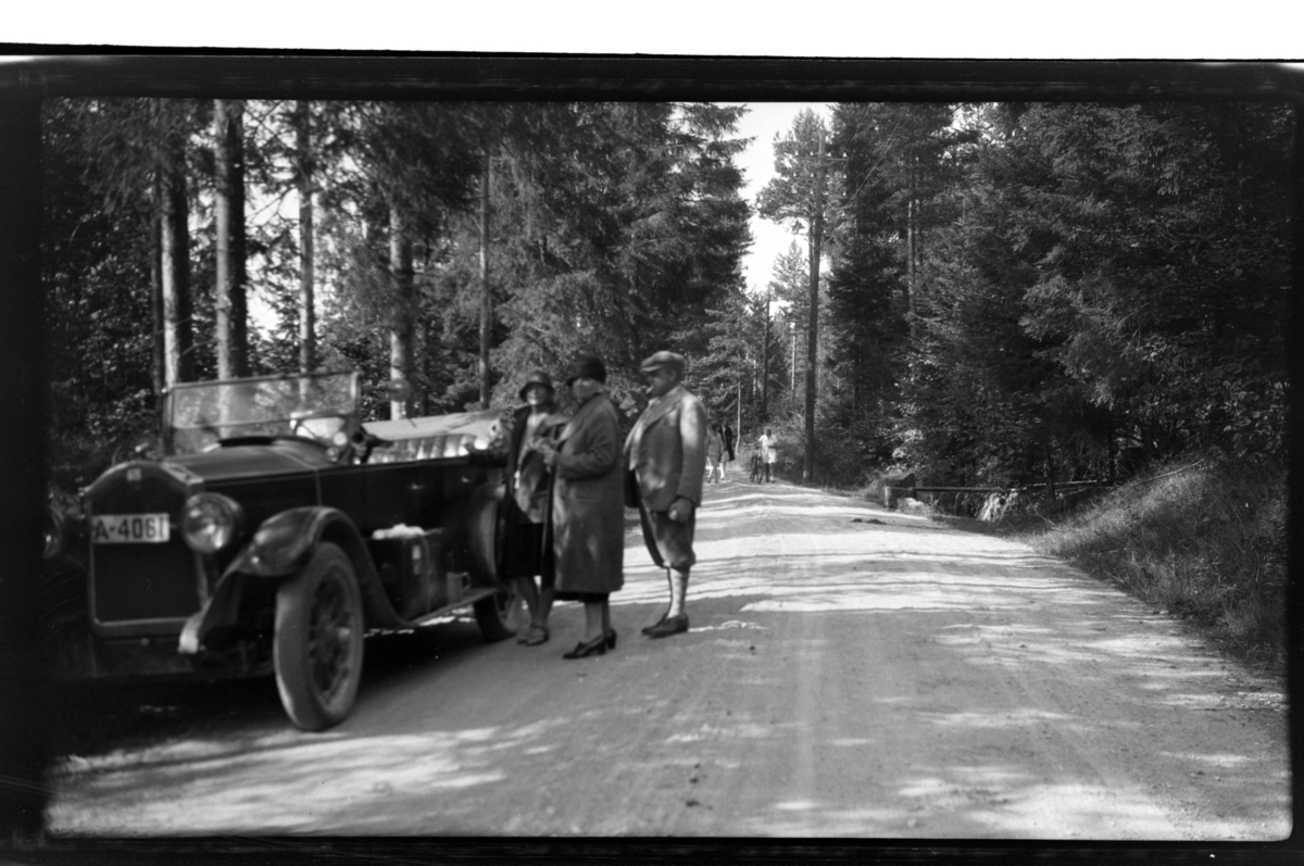 Rolf Sr. Sundt, Ekteparet Lauritz og Gerda Sundt står sammen med svigerinnen Hilda Sundt ved Rolf Sundt sr.'s Buick på en skogsbilvei. Fotografert 1930.