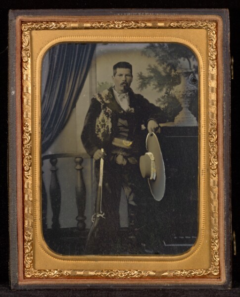 Unknown, [Portrait of Man in Studio with Rifle and Hat]
