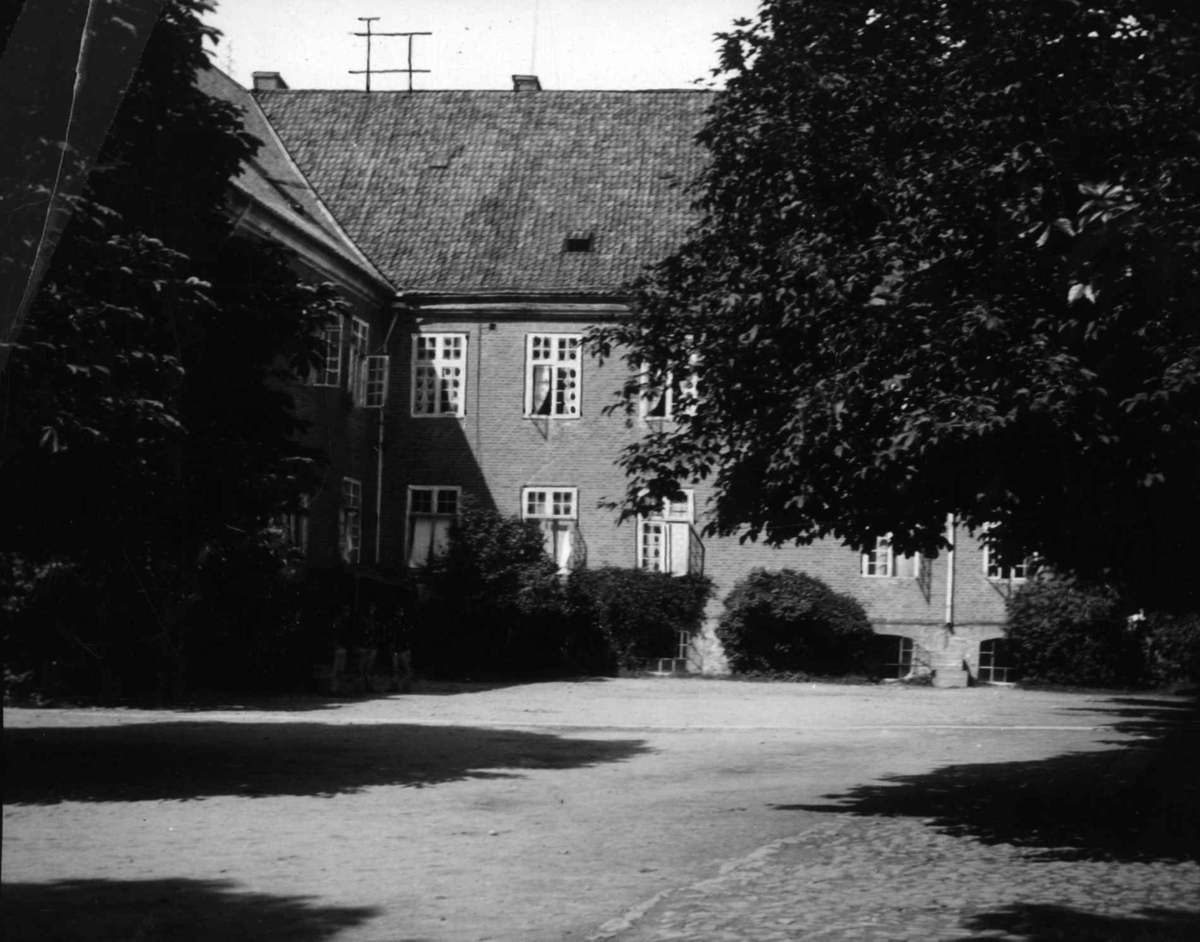 Hermann Christian Neupert, Postkort. Murstensbygning i to etasjer, del av gårdsplass, antatt del av festningen.