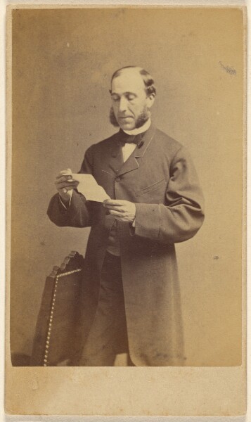 J. A. Whipple, [Man with muttonchops reading a letter, standing]