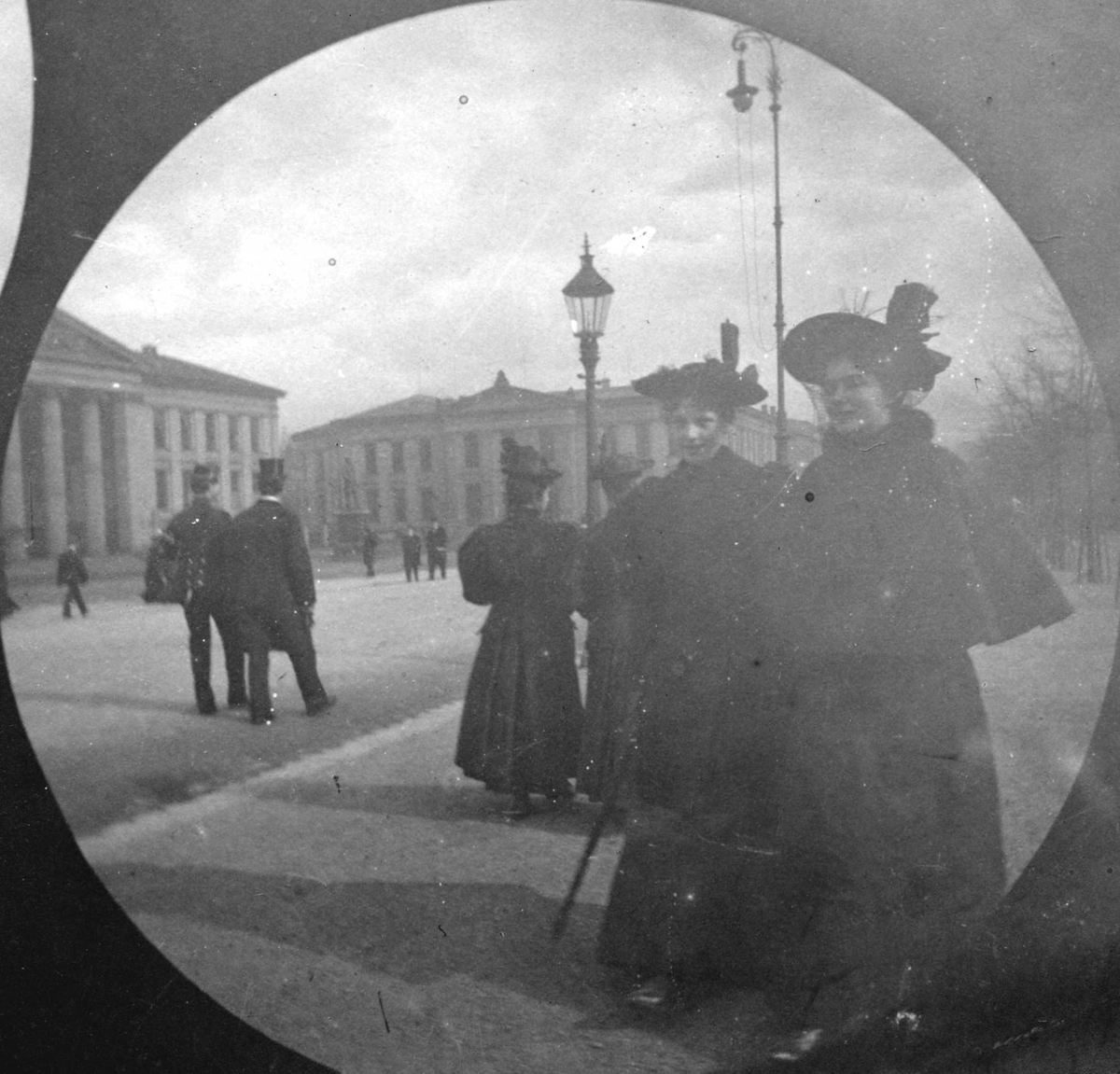 Fredrik Carl Mülertz Størmer, Frk.Lunde til venstre og frk. Røed spaserer langs Karl Johans gate, Oslo, med Universitetet på andre siden.