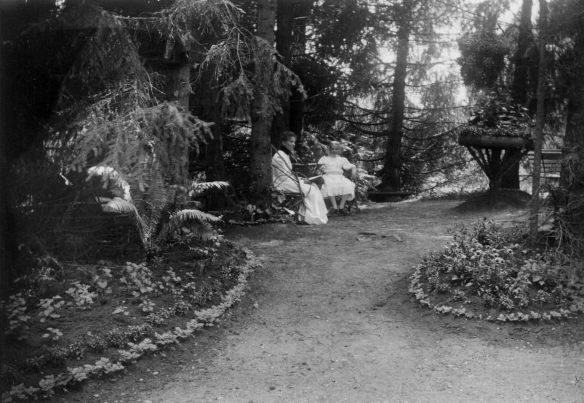 Fredrik Emil Faye, Dal gård, fra parken. Kvinne og pike på benk. Fra serie fotografert av kammerherre Fredrik Emil Faye (1844-1903), gårdens eier.