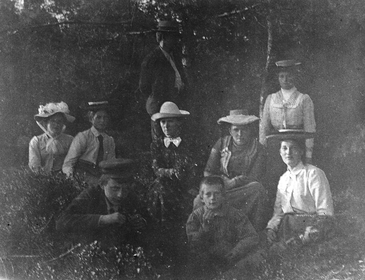 Juliane Fredrikke Langberg, Portrett av gruppe personer ute i naturen, ant. familie og venner av sokneprest Olaf A. Holm, fotografens svoger. Alle de 6 kvinnene bærer hatt. Kvinne nr.2 fra v. er muligens fotografen Fr. Juliane Langberg. Nr.3 fra v. er Karen Skarpsno, pike hos Holms fra 1886. Christian L. Holm, gutten foran t.…