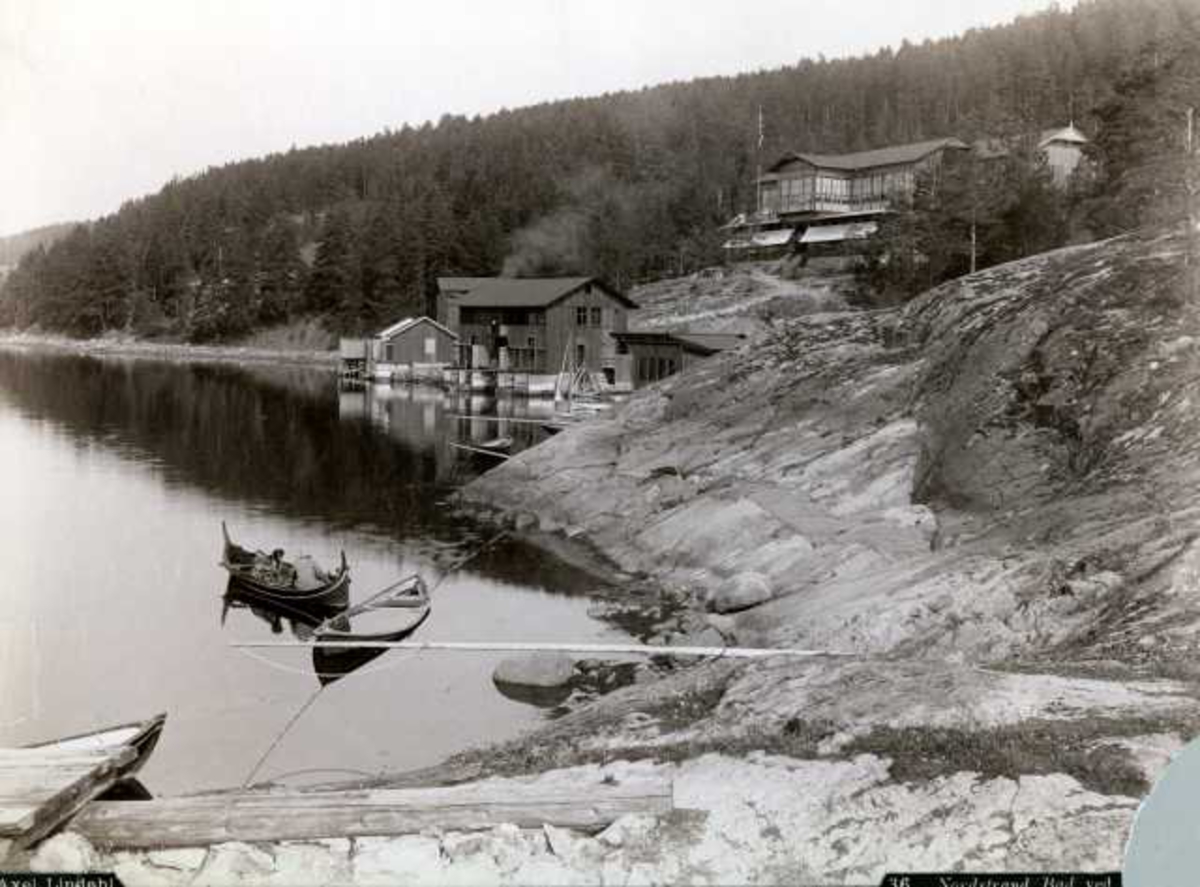 Axel Lindahl, Nordstrand bad, Oslo. Fra stranden med mennesker i båt, hus i bakgrunnen.