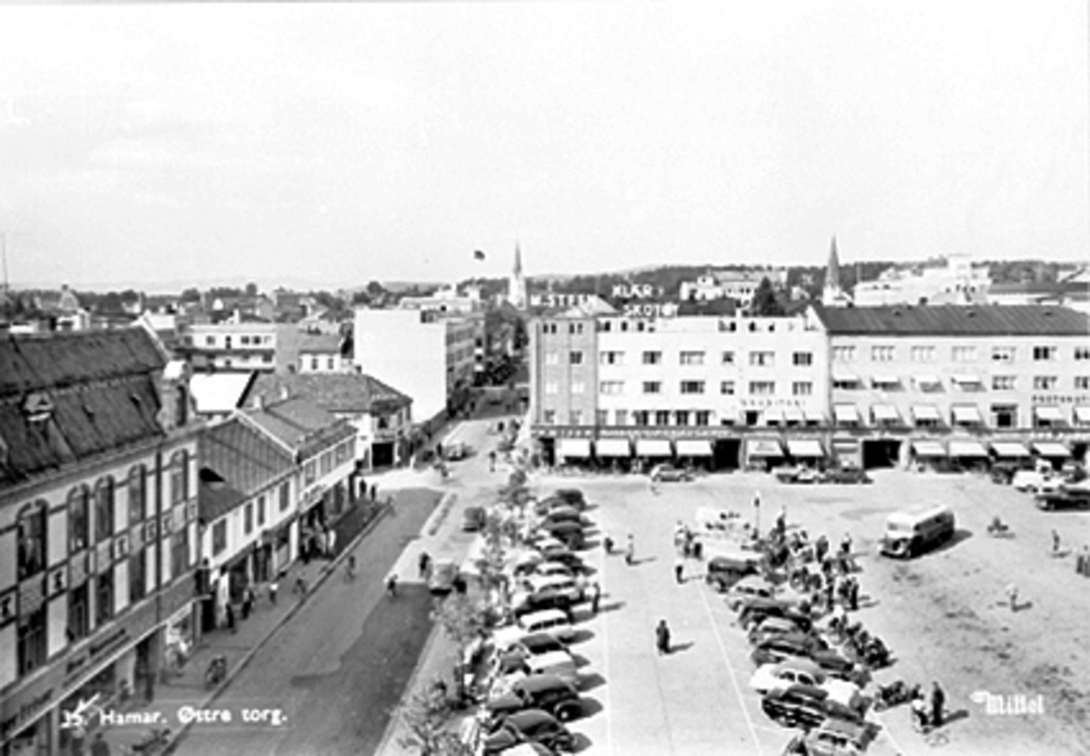 Anno Domkirkeodden, OVERSIKT ØSTRE TORG, TORGGATA/VANGSVEGEN MOT TRIANGELEN, PARKERTE BILER, BUSS, FOLK