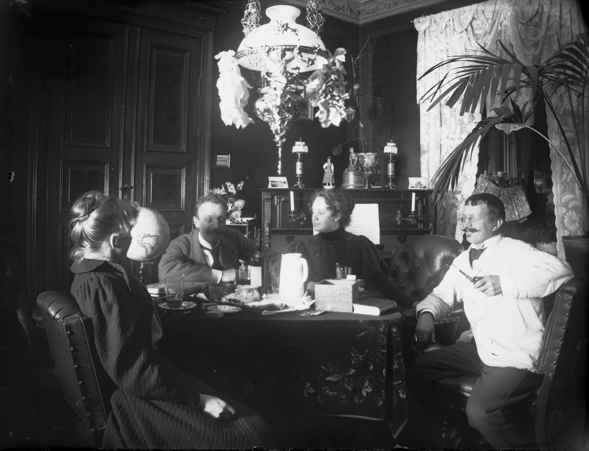 Axel Quinsgaard Wiborg, Stueinteriør, Munkedamsveien 65B, Oslo. Mennesker sitter rundt bord, 1903. Gudrun Q. Wiborg, Axel Q. Wiborg, Edle Thoresen, advokat H.J. Schwartz.
