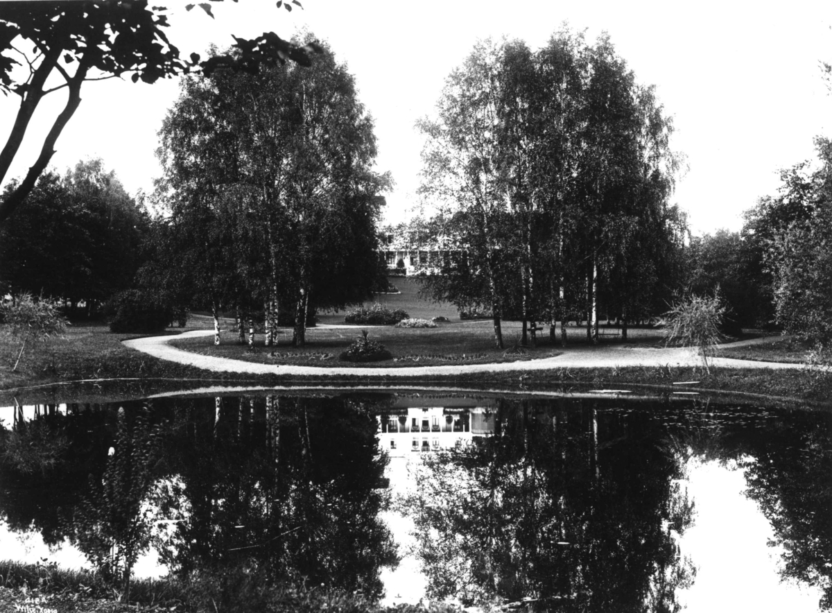 Anders Beer Wilse, Skøyen hovedgård, Oslo 1903. Huset sett fra parken med dam i forgrunnen.