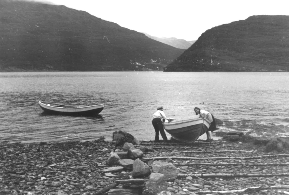 Anna Grostøl, Båtstø. To personer drar en småbåt på land. Olderdalen, Kåfjord, Troms 1947.