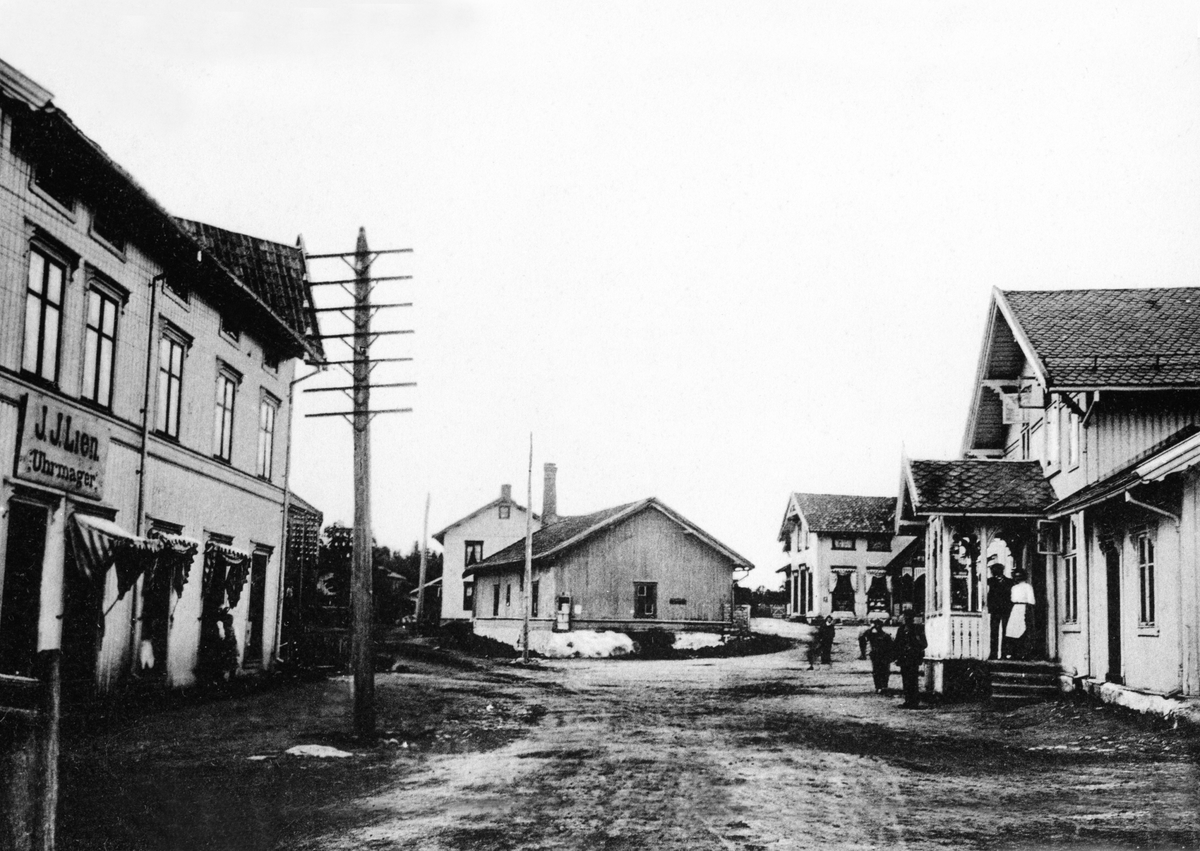 Anno Domkirkeodden, POSTKORT. STASJONSVEGEN, LØTEN SENTRUM, DET GAMLE TORGET PÅ "STASJON ", KRYSSET MELLOM VEGEN FRA VENSBAKERIET OG "MEIERIGUTUA", MOT LØITENS HANDELSFORENING, 1905-10. LØITENS HANDELSFORENING BLE ETABLERT OG BYGD I 1873, MED BESTYRERBOLIG OG BAKERI. LILLEBERG, BYGGET AV DYRE LARSENS, LØITEN KOOPERATI…