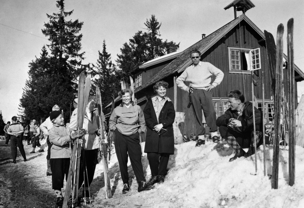 Anno Domkirkeodden, EKSTRIØR BUDOR TURISTHYTTE, FOLK I SKIANTREKK, M/STREKKBUKSER OG NIKKERS, SKI, STAVER, VINTER, BUDOR, LØTEN. Mannen som står på snøkanten i lys genser er Arne Grøndahl.