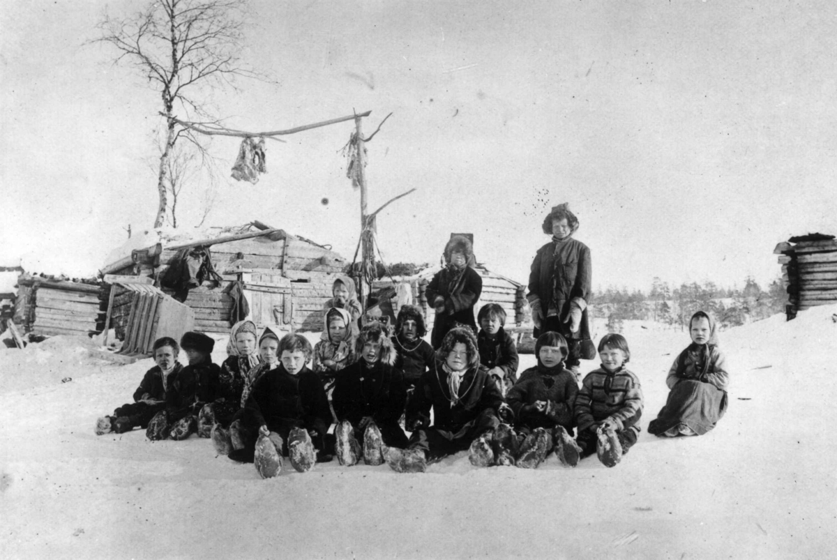 Ellisif Rannveig Wessel, Skoltesamiske skolebarn sitter i snøen ved Pasvik-siidaens skole, Pasvik, Sør-Varanger, Finnmark, 1898.