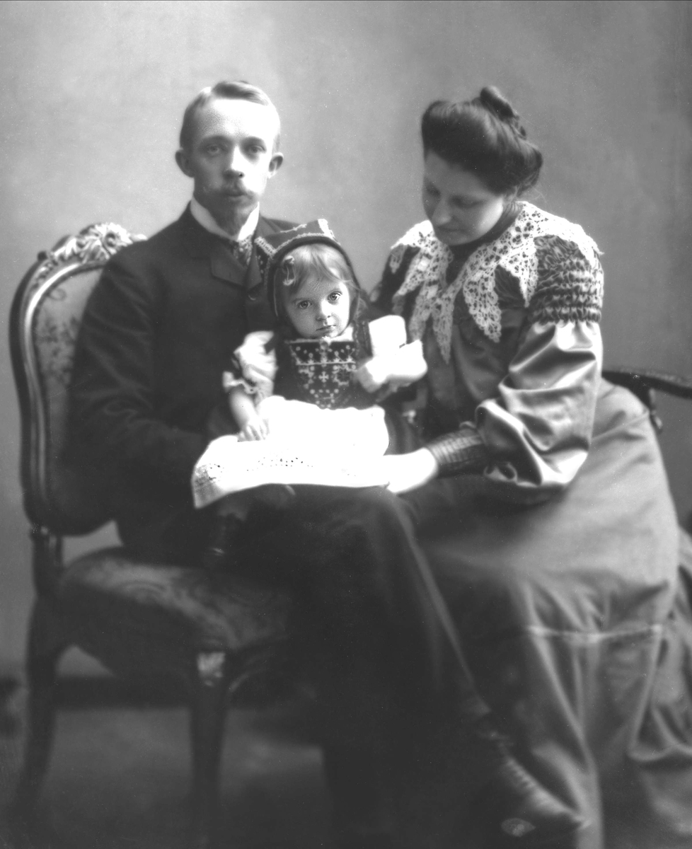 Gustav Borgen, Gruppeportrett, mann og kvinne sitter med et barn på fanget.