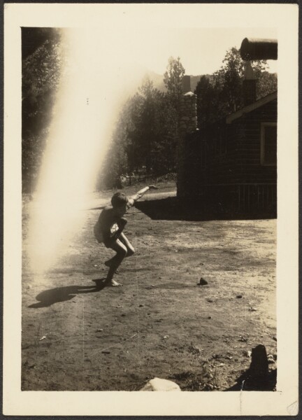 Louis Fleckenstein, [Kenneth Heaving Rock at Cabin]