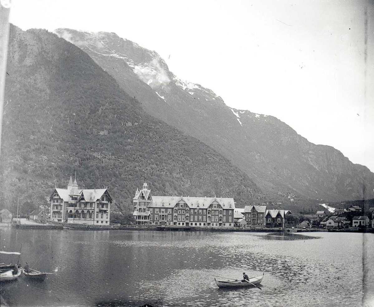 Tom Kent, Bilde fra sjøen mot Hotell Hardanger og Odda. Tre robåter på sjøen.