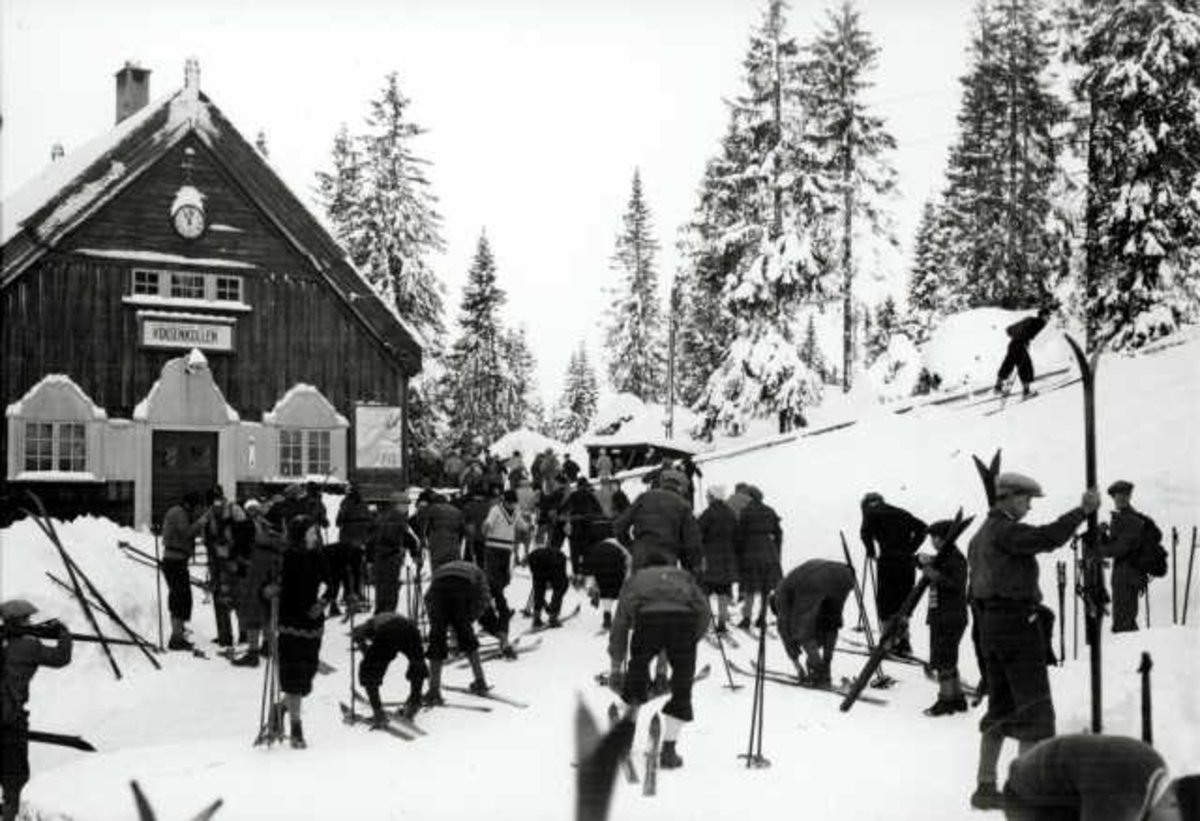 Hermann Christian Neupert, Voksenkollen stasjon, Nordmarka, Oslo. Vintermotiv. Skiløpere på stasjonen..