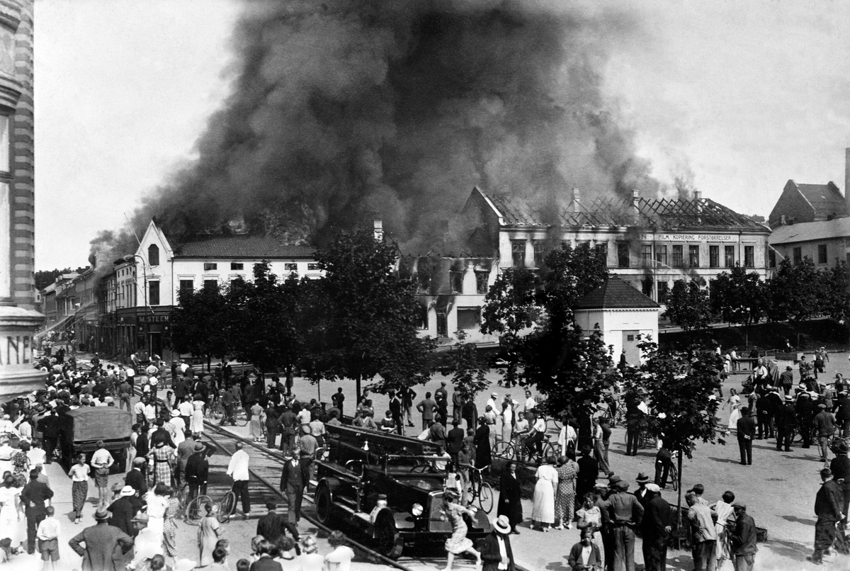 Anno Domkirkeodden, BRANN PÅ ØSTRE TORG, POSTHUSGÅRDEN, STIGEBIL, BRANNBIL, MYE FOLK, CARL NORMANNS FOTOGRAFIARKIV GIKK TAPT. Bybrann. Se også 0401-02526, 0401-05067, 0401-02920, 0401-00706, 0401-05965 og 0401-00581.