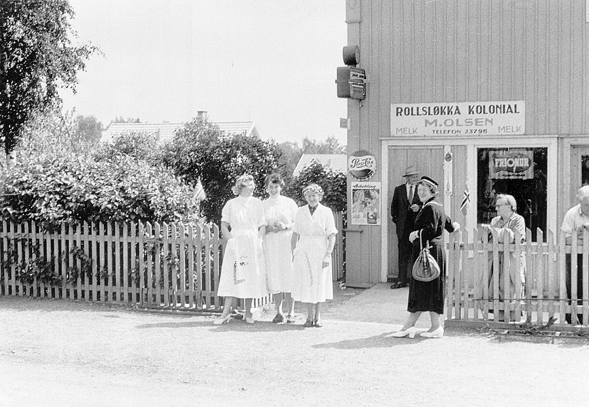 Anno Domkirkeodden, ROLLSLØKKA KOLONIAL. BUTIKK. BETJENING OG FOLK FORAN, FRA VENSTRE: LAURA BEKKELUND, SIGRUNN RØNNINGEN, HILDA OLSEN ( f. Nilsen), VED GJERDET: VALBORG SVAANAA, JOHANNE OLSEN OG INNEHAVER: MARTIN ALBERT OLSEN (17. 09. 1885-24. 09. 1968), MANN I BAKGRUNN: THORVALD SVAANAA, HOLSETGATA 79, HAMAR.