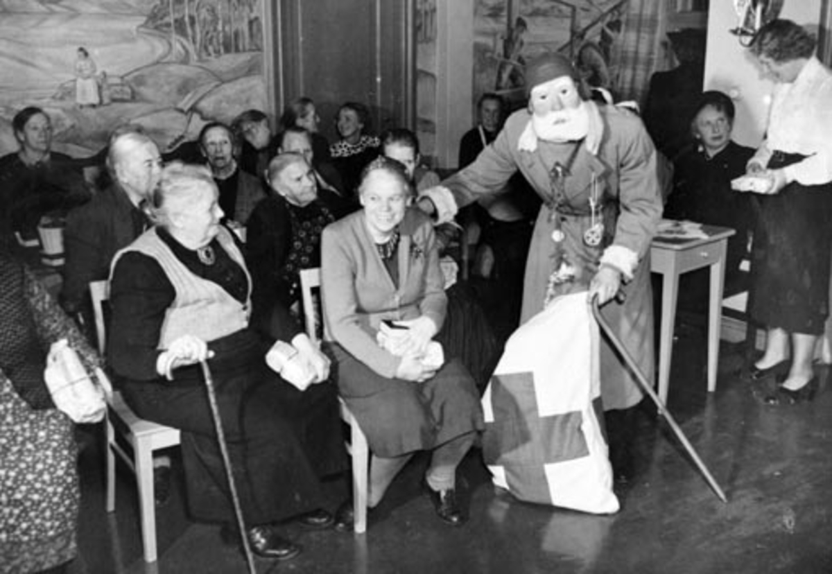 Anno Domkirkeodden, HAMAR RØDE KORS ARBEIDSGRUPPE 4, DELER UT JULEGAVER PÅ GAMLEHJEMMET. JULENISSE OG BEBOERE. HAMAR SYKEHJEM. FOTO NORMANN, HAMAR 18. 12. 1949 SE OGSÅ NEG. NR. NO 37505