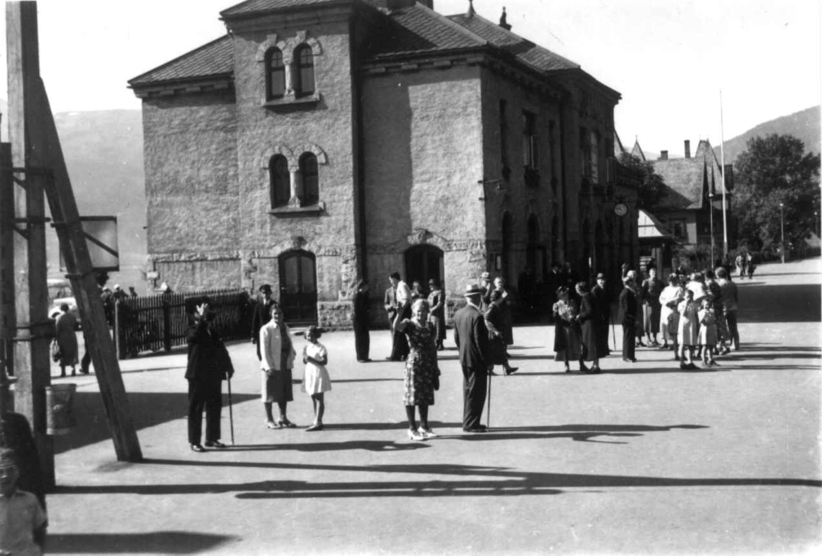 Hermann Christian Neupert, Voss jernbanestasjon 1939. Foran stasjonsbygningen. Passasjerer på perrongen.