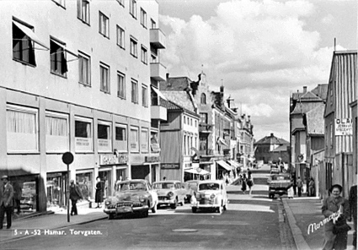 Anno Domkirkeodden, TORGGATA SETT FRA KRYSSET TORGGATA. /VANGSVEGEN MOT JERNBANESTASJONEN, BILTRAFIKK OG FOLKELIV