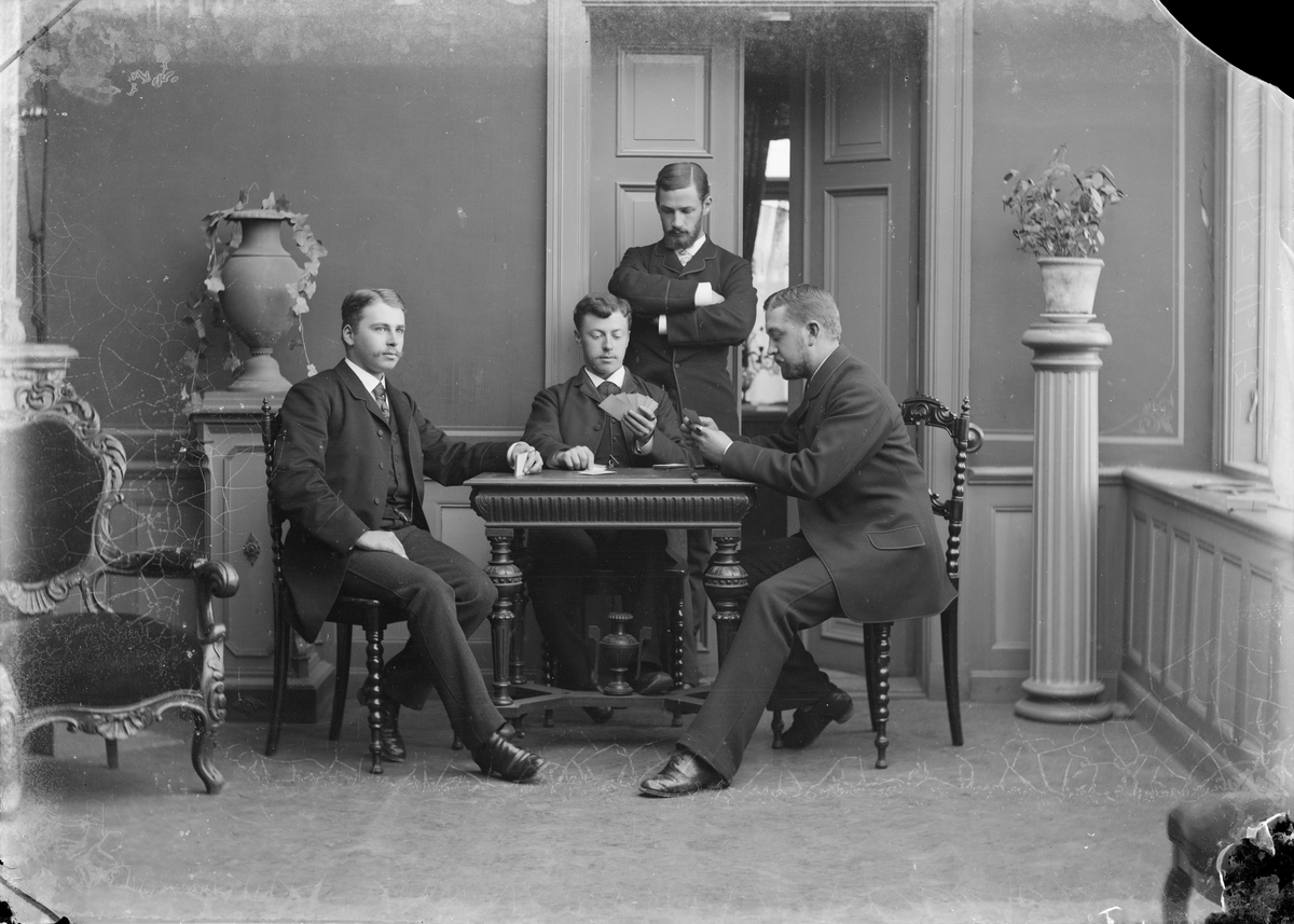 Henri Osti's Fotografiateliér, Bernhard Palmgren and three other men play cards, Uppsala 1884