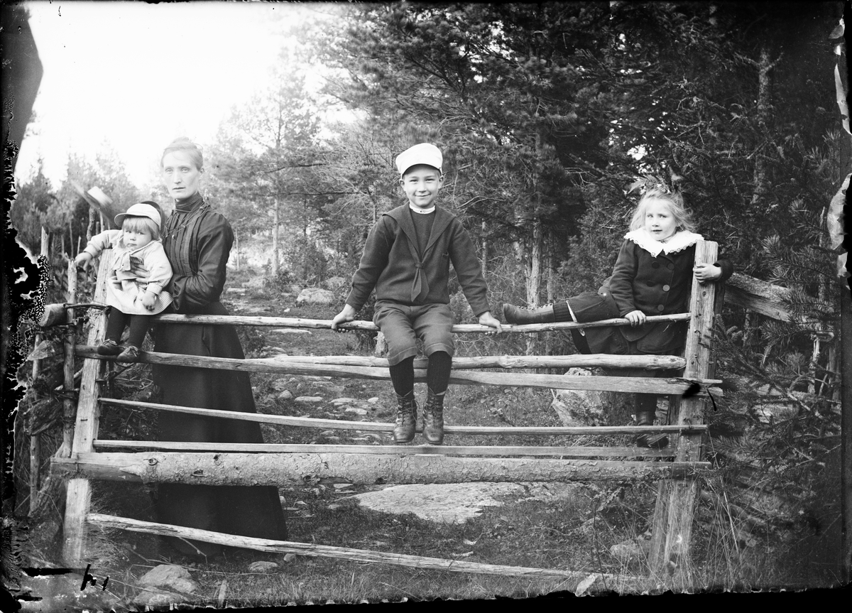 Skötsner-Edhlund, Per Elis Edhlunds syster tillsammans med Per David, Josef och Sara Edhlund som sitter på grind, Östhammar, Uppland