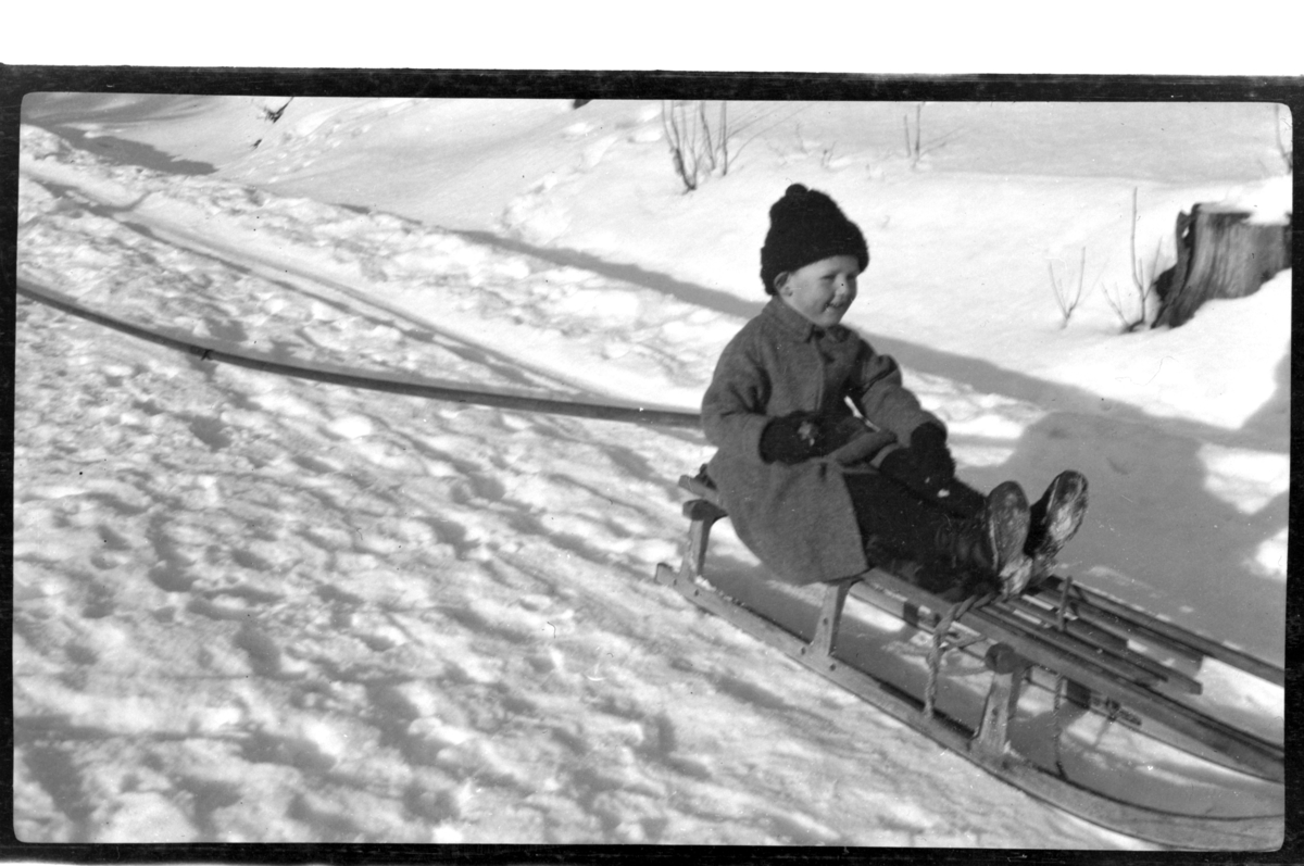 Rolf Sr. Sundt, Julius Sundt sitter på en kjelke. Fotografert 1920.