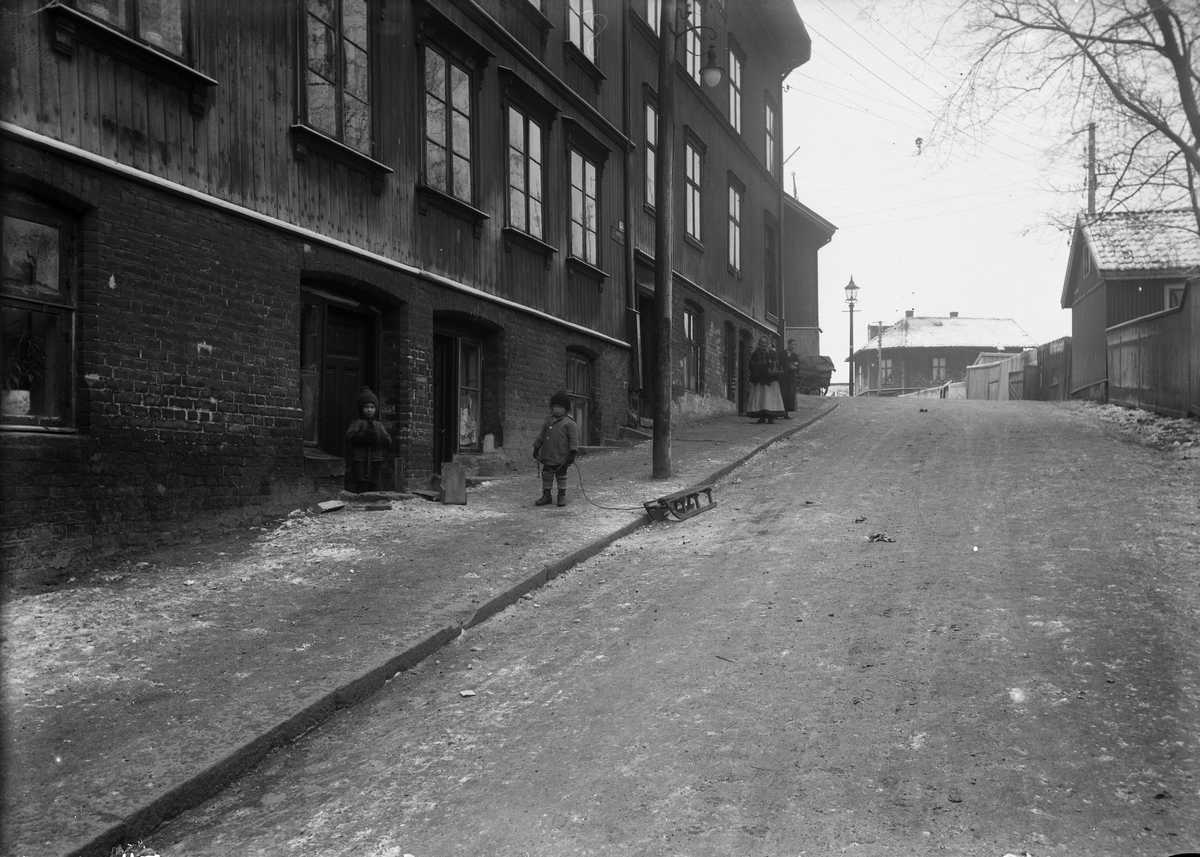 Nanna Broch, Solhauggata ogTromsøgata, Rodeløkka, Oslo. Barn med kjelke på fortauet foran bygårder. Fra boliginspektør Nanna Brochs boligundersøkelser i Oslo 1920-årene.