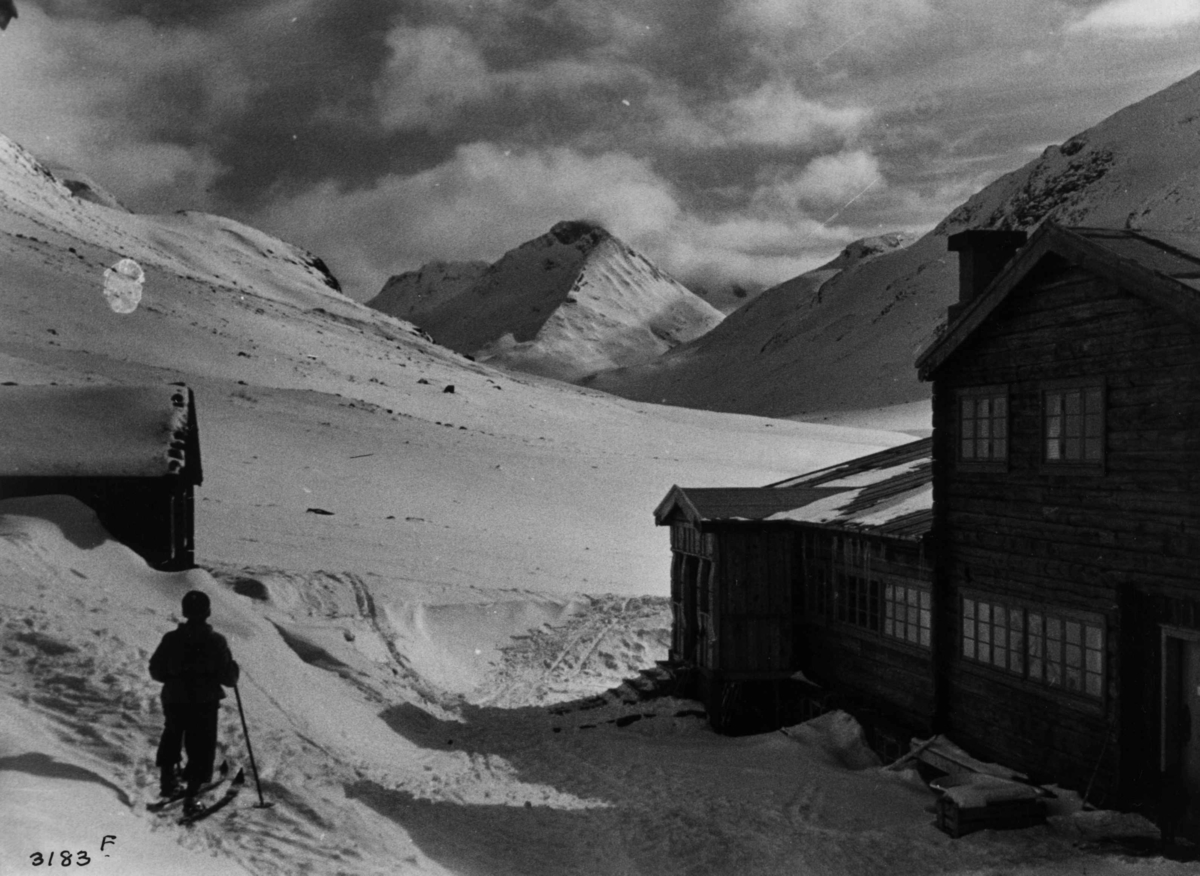 Anders Beer Wilse, Skiløper ved Spiterstulen i Visdalen i Jotunheimen med snødekte fjell.