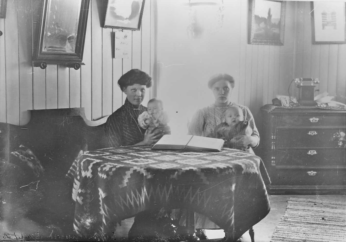 Peder J. Bredalslien, To kvinner med barn ved bord.