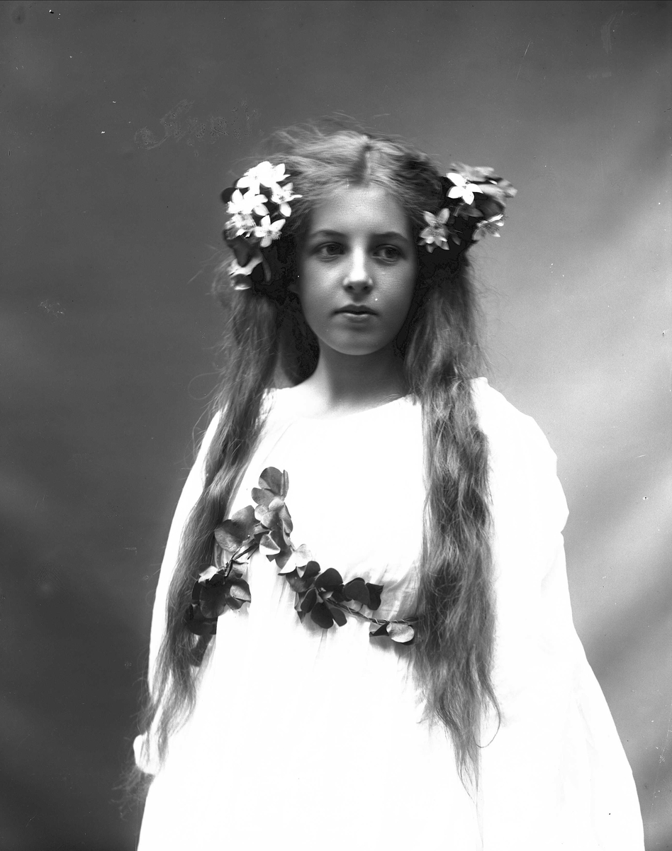 Solveig Lund, Studioportrett av kvinne i drakt med blomster i håret.