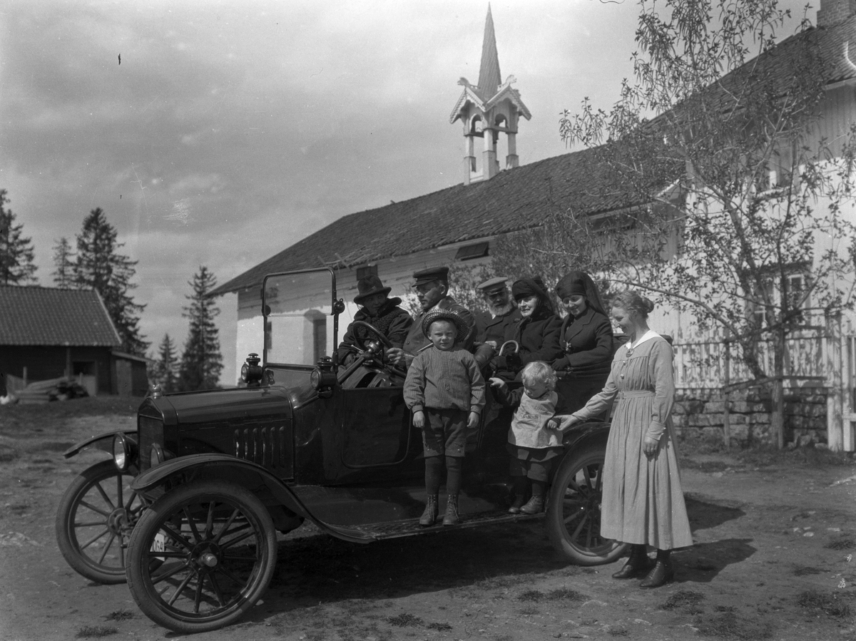 Kristian Heramb, Åtte personer ved en bil. Iver Heramb ved rattet, med skjegg Andreas Heramb. Barna: Andreas og Ole sammen med moren Olave (f. Sang). De andre er ukjente. D-064.