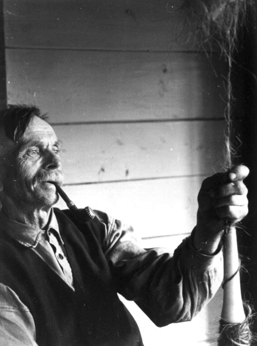 Anna Grostøl, Sigmund Rudlende på Rossevatn spinner på håndrokk. Eiken, Hægebostad, Vest-Agder 1941.