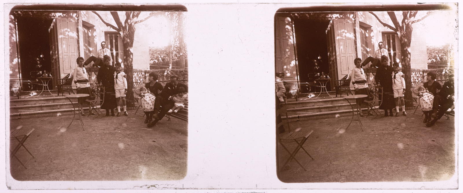 Desconegut, [Group of people in front of home]