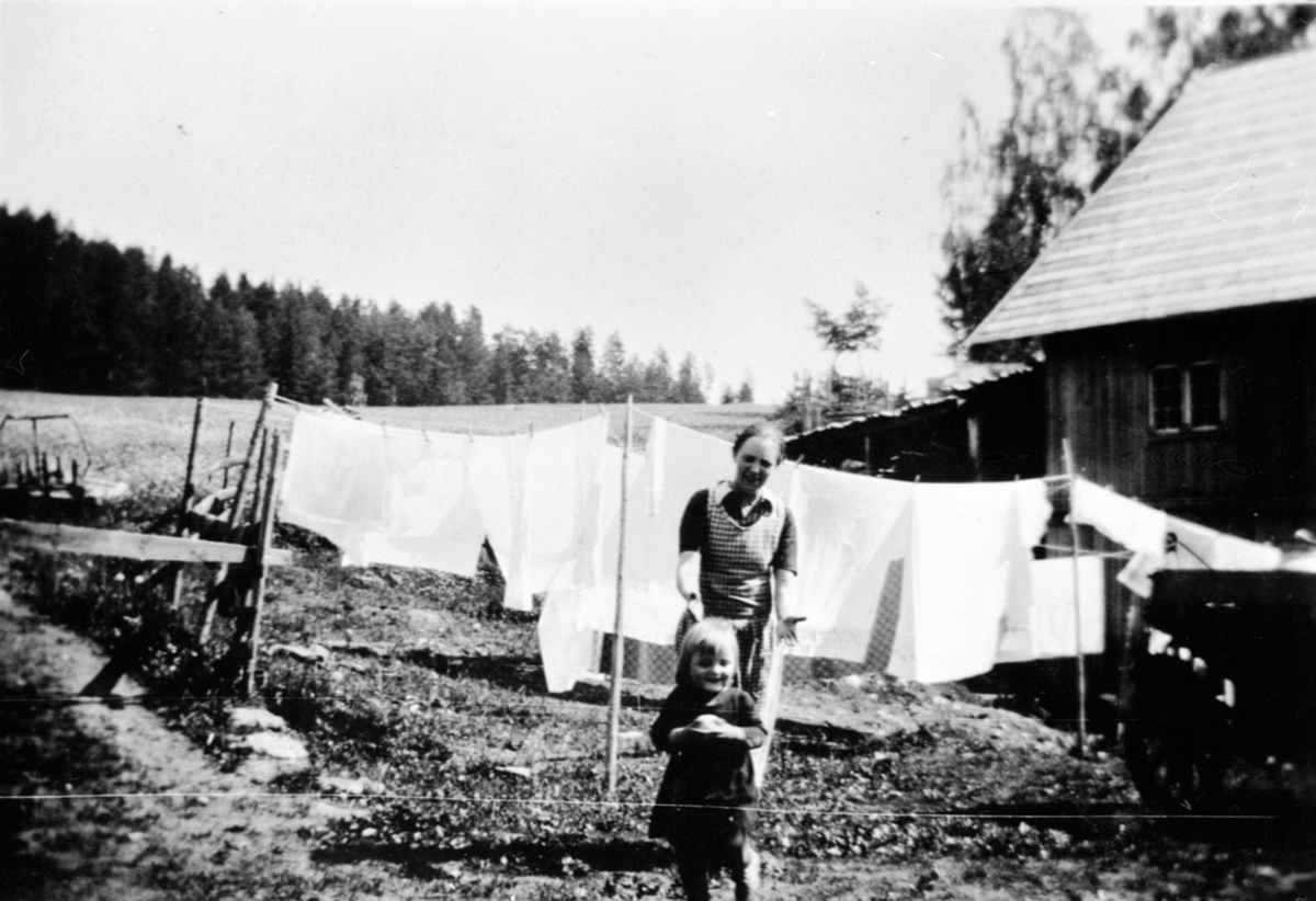 Anno Domkirkeodden, Klesvask til tørk. Alvhild Sandbæk f.1905 med datter Else Marie på Raknerud nordre, Helgøya.