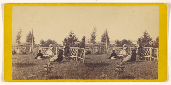 Unknown, [Three women and a man wearing a top hat posed at a fence]